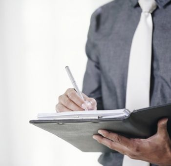 Close-up image of businessman signing contracts in folder